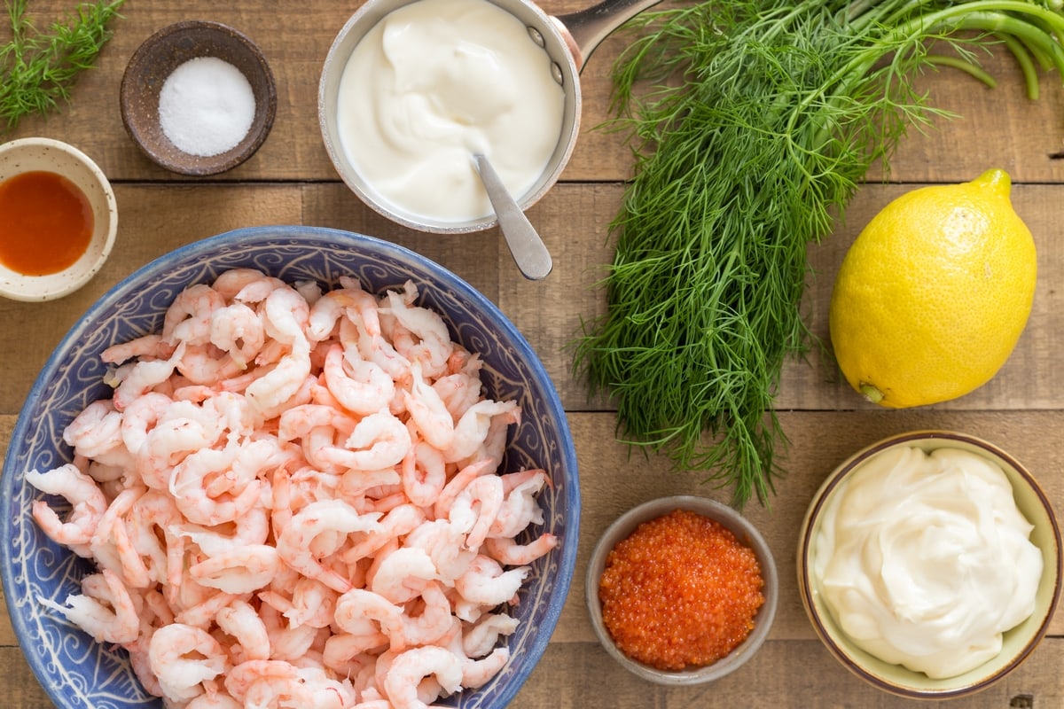 Ingredients needed to make Swedish shrimp salad: hand-peeled shrimps, mayo, sour cream, gill, lemon, fish roe and sriracha.