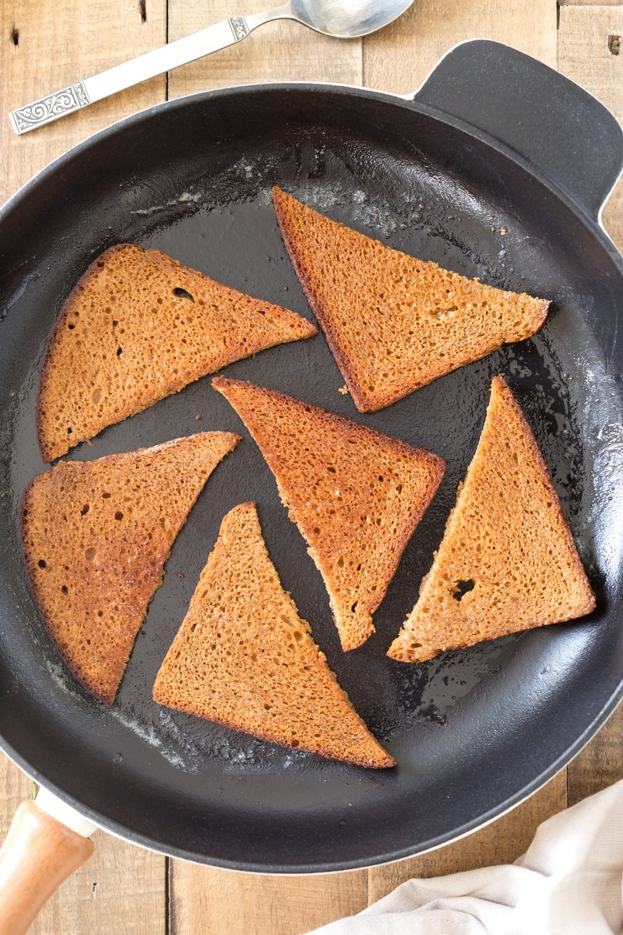 Rye bread slices toasted in butter in cast iron skillet.
