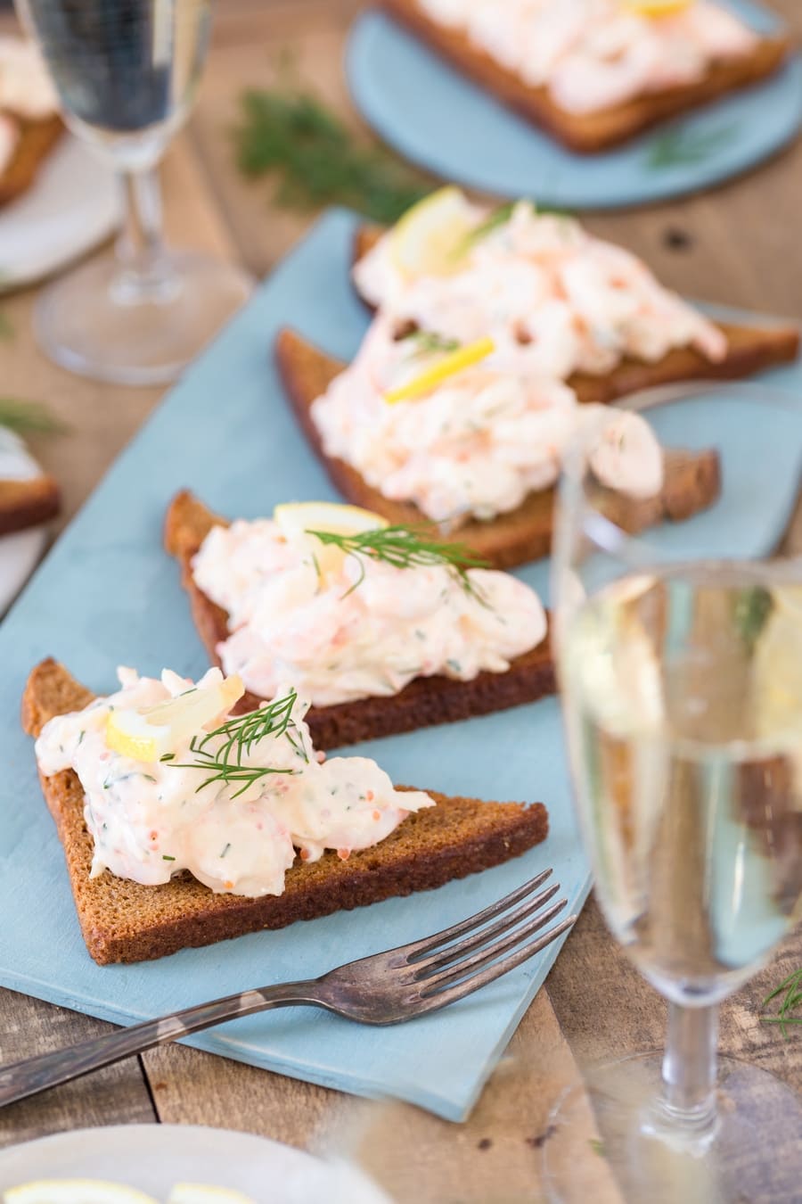 Swedish skagenröra shrimp salad on toasted rye bread, served with prosecco.