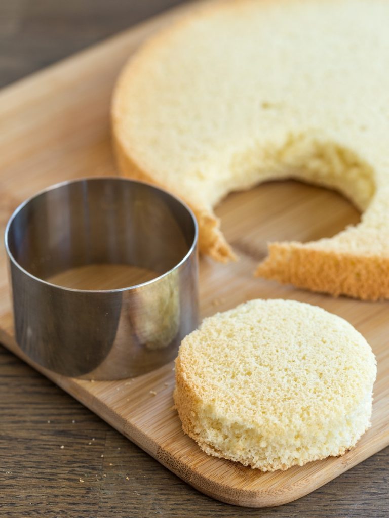 Cutting out discs of sponge cake using a pastry ring.