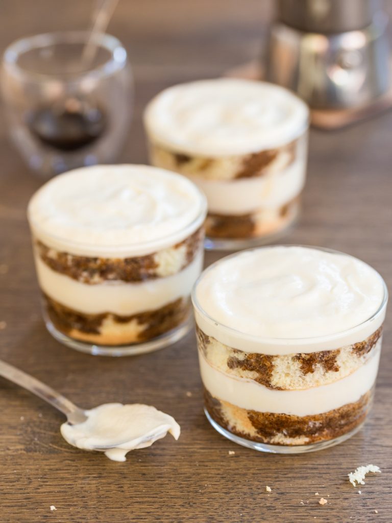 Single serve tiramisu cups ready to be dusted with cocoa.
