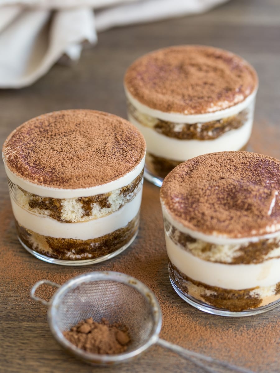 3 cups of tiramisu showing the layers of sponge cake and mascarpone cream.