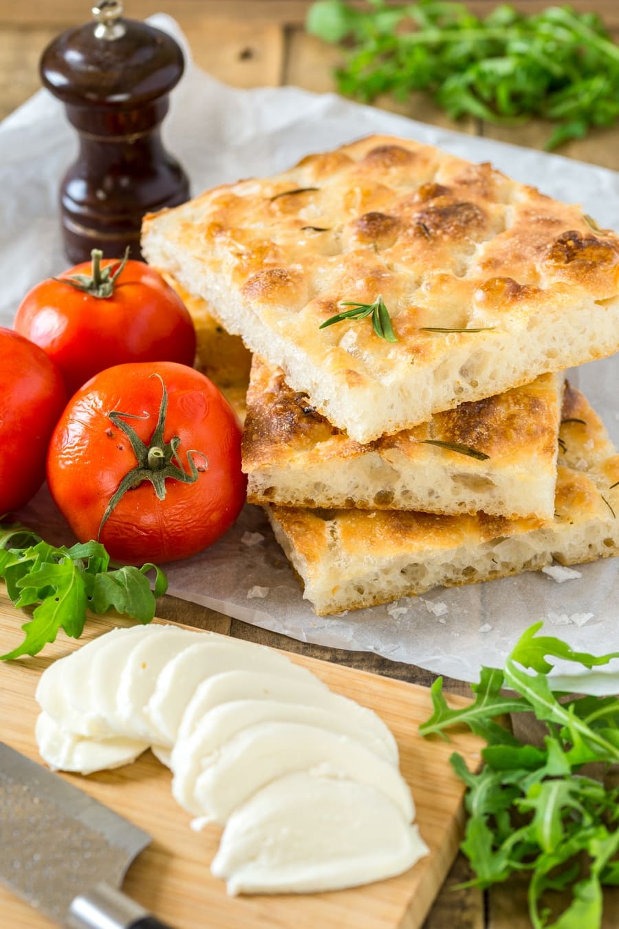 Fresh tomatoes, focaccia slices, sliced mozzarella, pepper and rucola: the ingredients to make caprese focaccia sandwich.