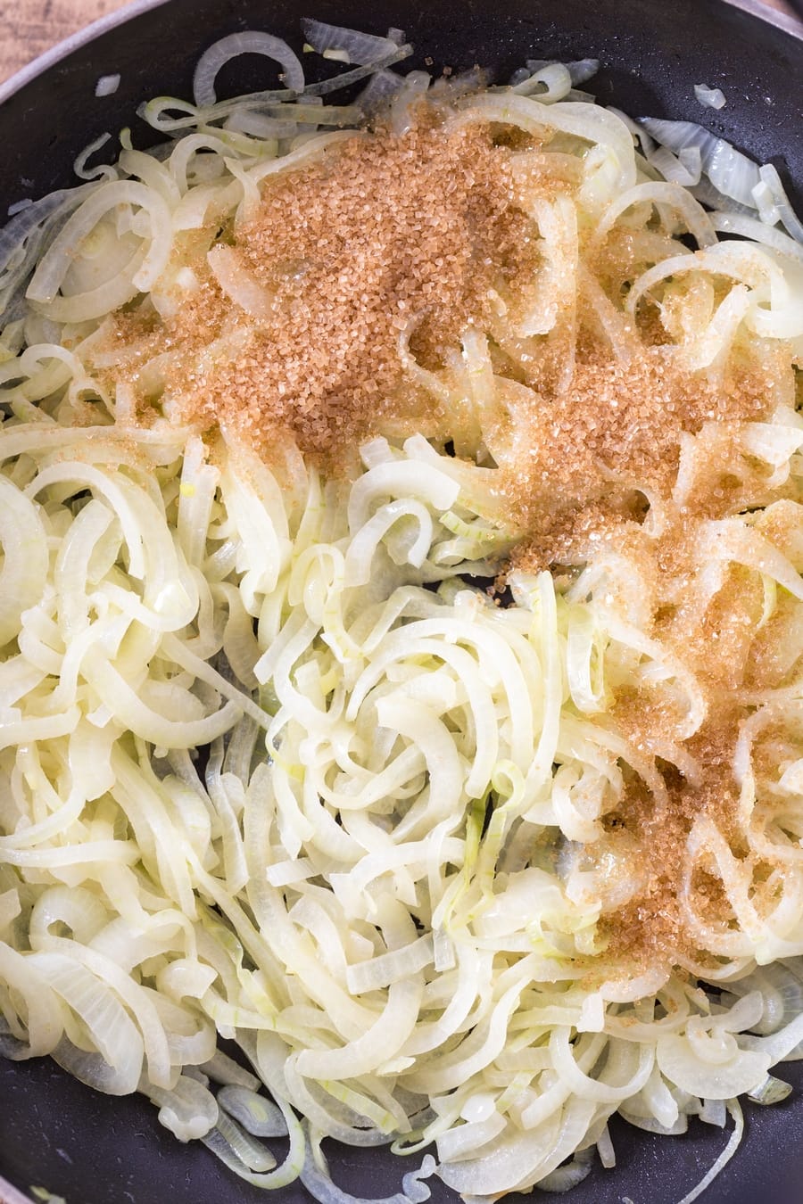 Brown sugar added to sautéed sliced onions.
