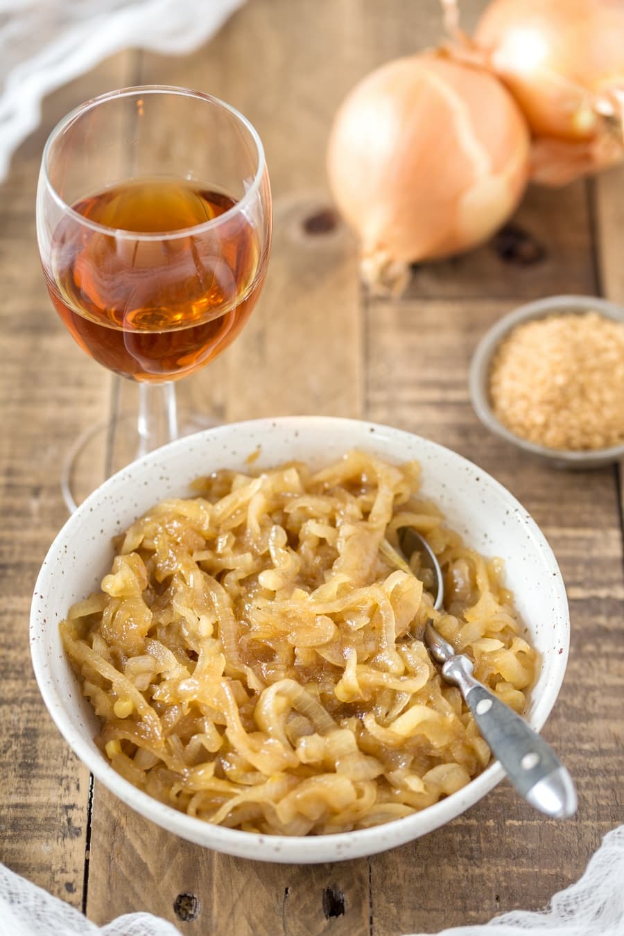 Caramelized onions with marsala on a wooden table.