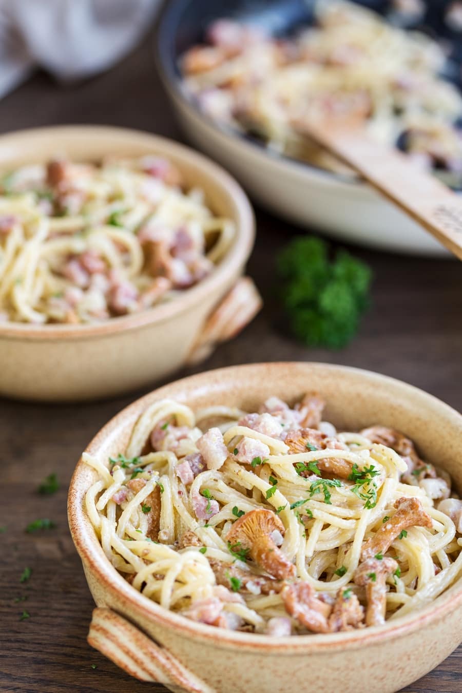 Two bowls of honey mushroom pasta with bacon and mushrooms.