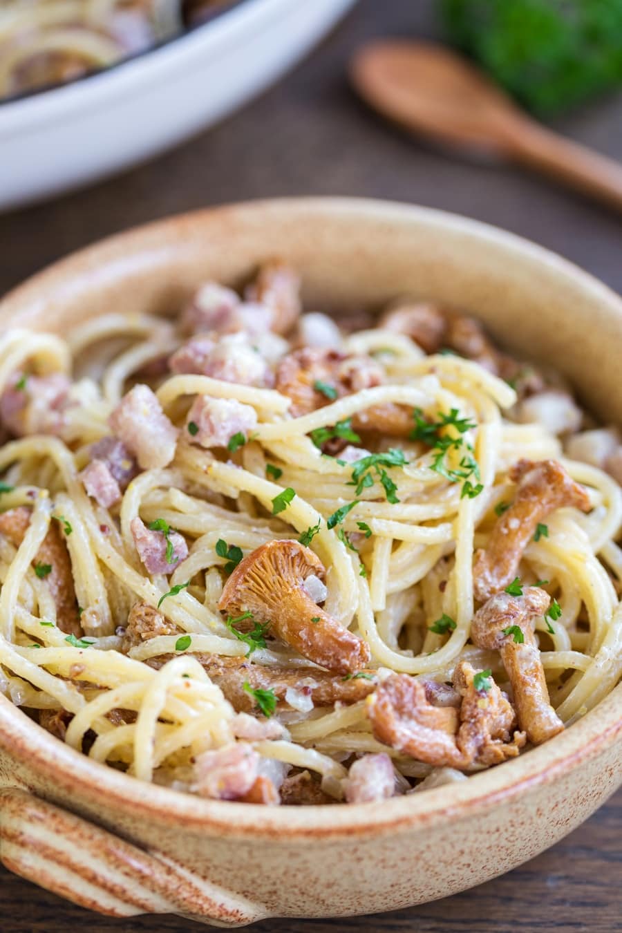 Bowl of honey mustard pasta with bacon and mushrooms.