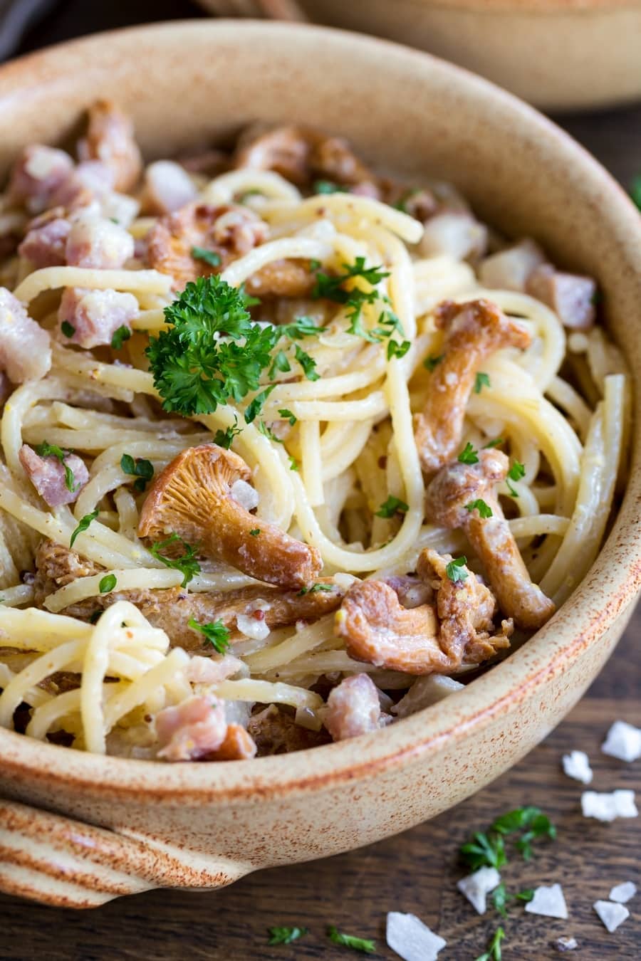 Closeup of creamy mustard pasta with bacon and chanterelles.