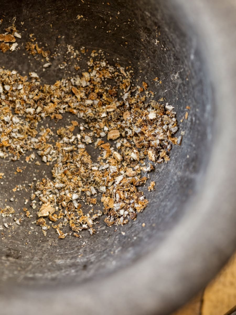 Crushed cardamom seeds in a mortar.