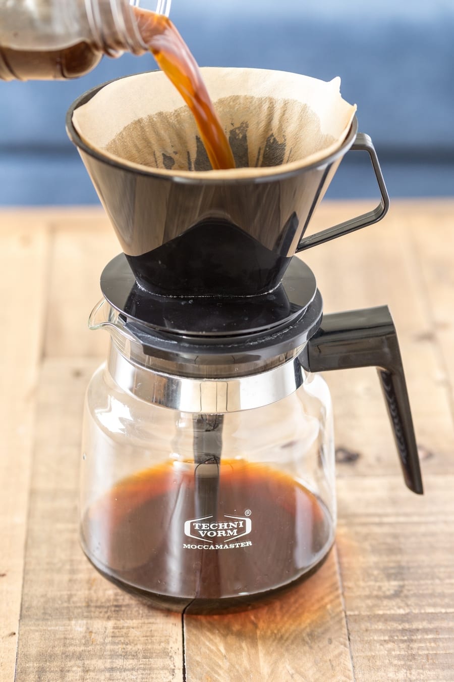 Cold brew coffee being filtered through a pour-over coffee maker.
