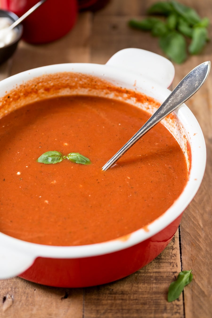 Zupa pomidorowa served in a red and white pot.