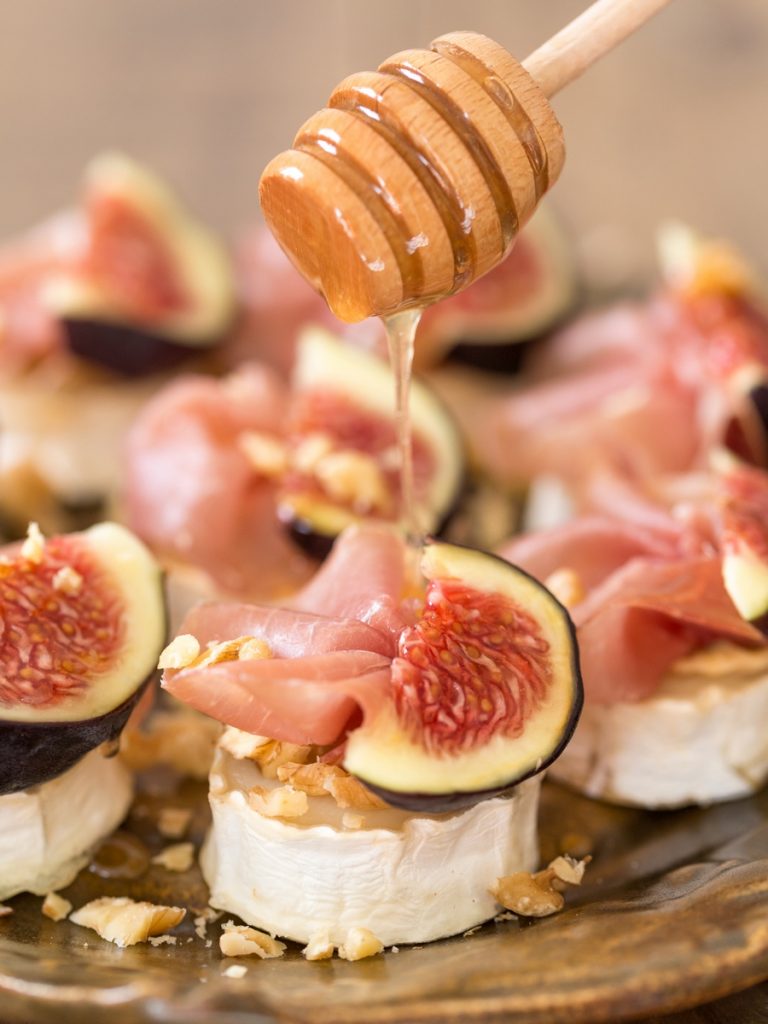 Drizzling honey over baked goat cheese with figs.