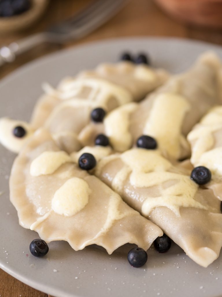 Bilberry pierogi with sour cream and sugar,