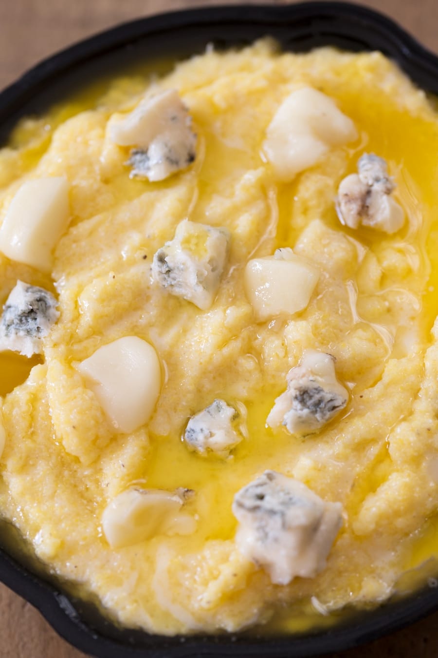 Unbaked polenta concia: a layer of cheese and melted butter top the polenta.