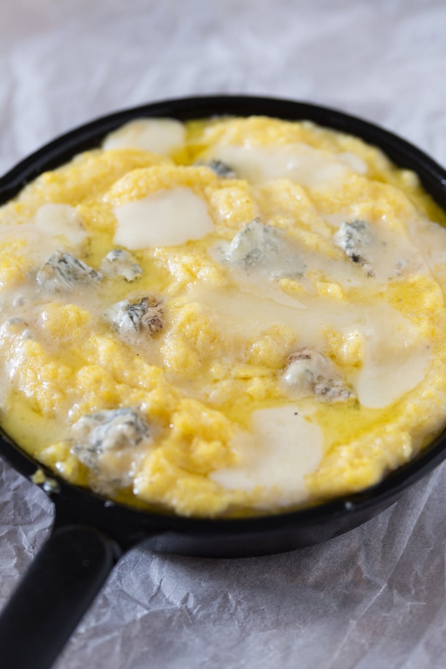 Baked polenta concia in a cast iron skillet.