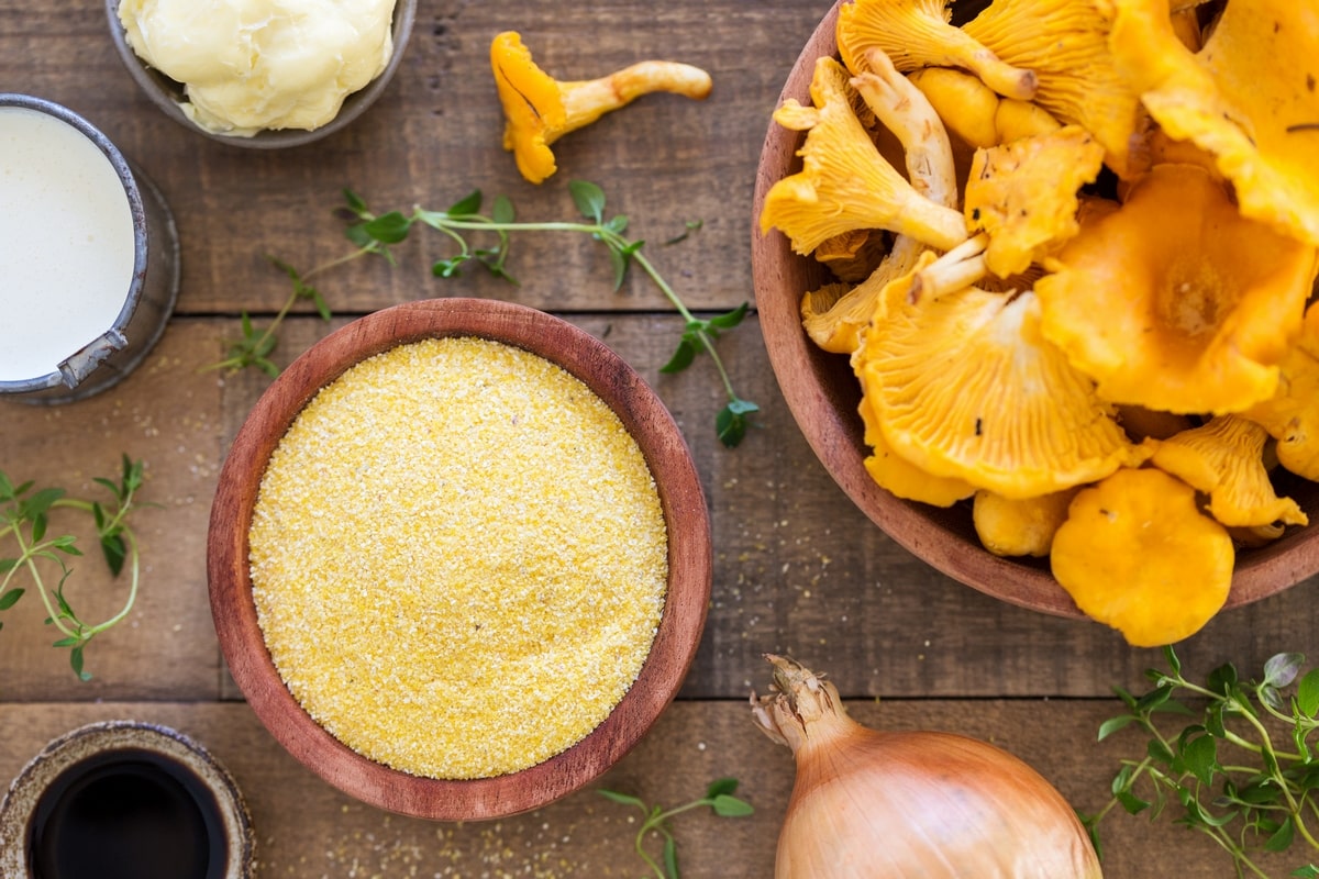 Overhead view of polenta chanterelles, an onion and small bowls with condiments.