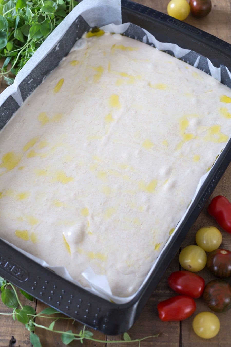 Baking tin with poolish focaccia bread in it, proofing.