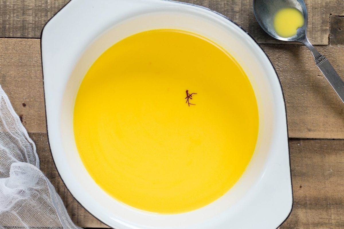 Cooking saffron panna cotta n an enamel saucer.