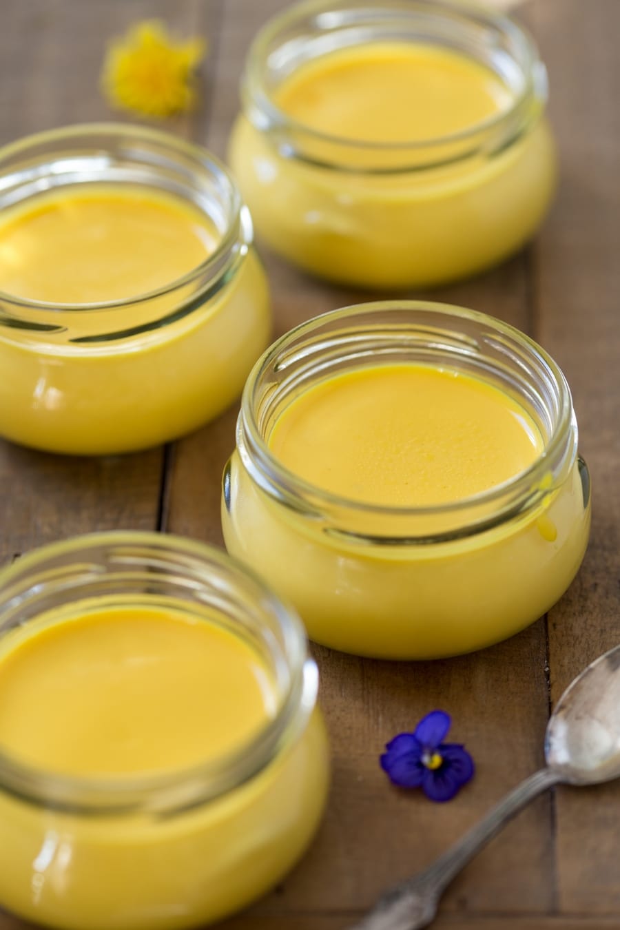 Saffron panna cotta served in small glass containers.