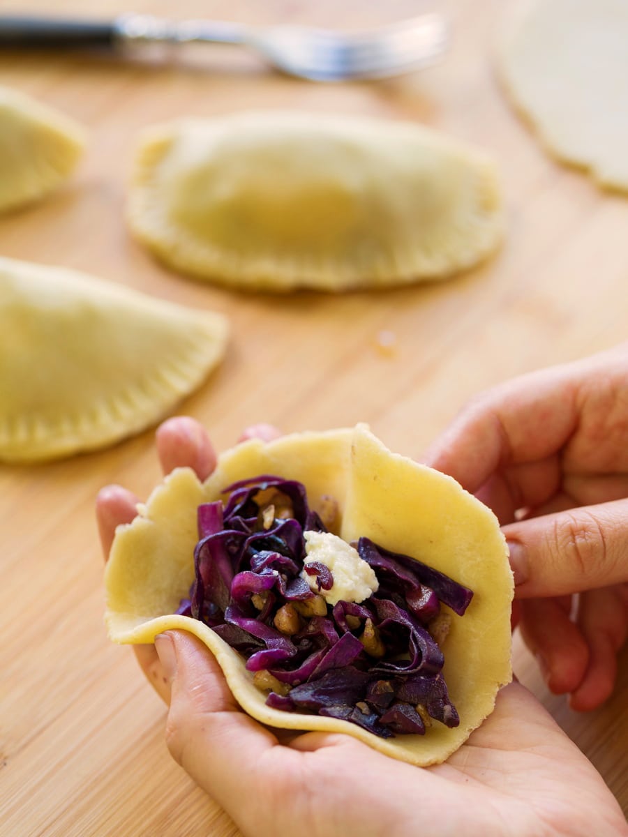 Assembling red cabbage veggie empanadas.