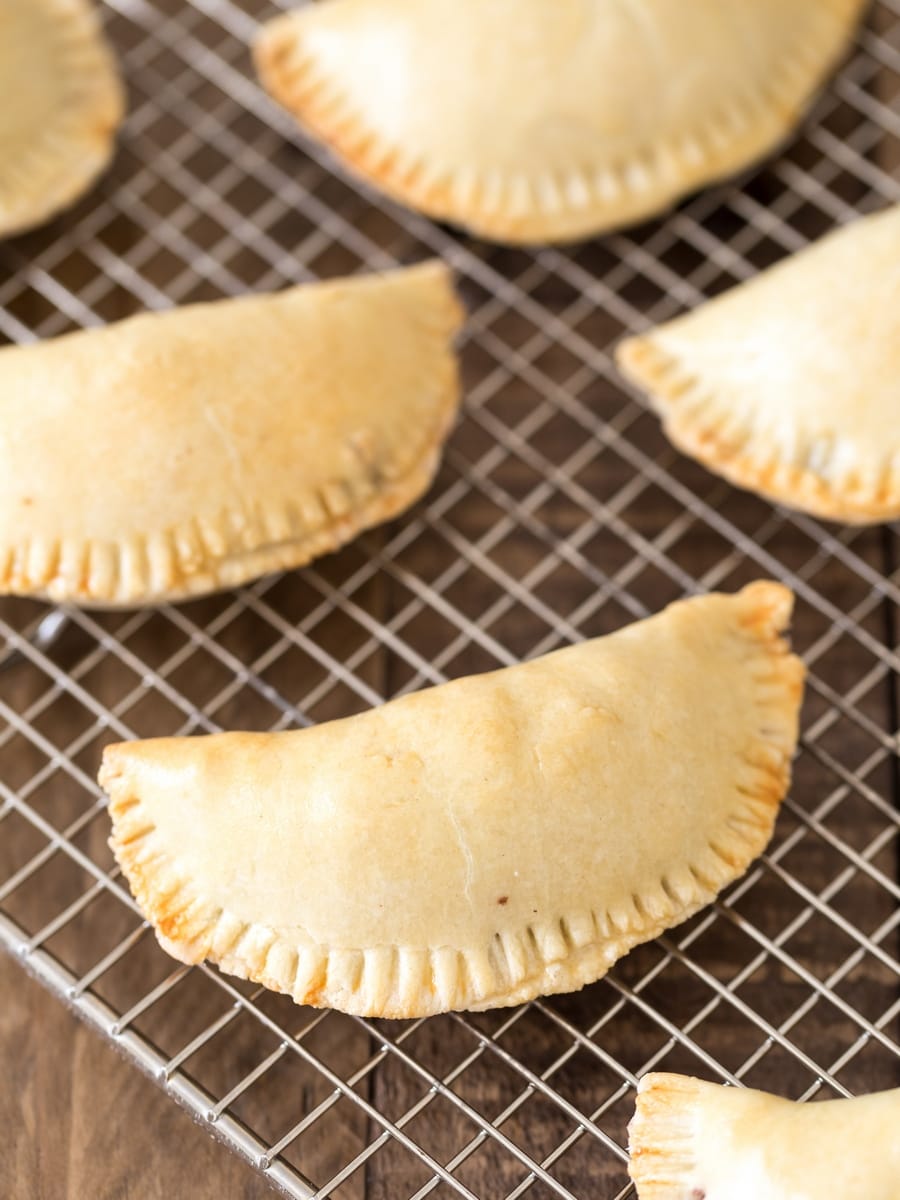 Baked empanadas on a cooling rack.
