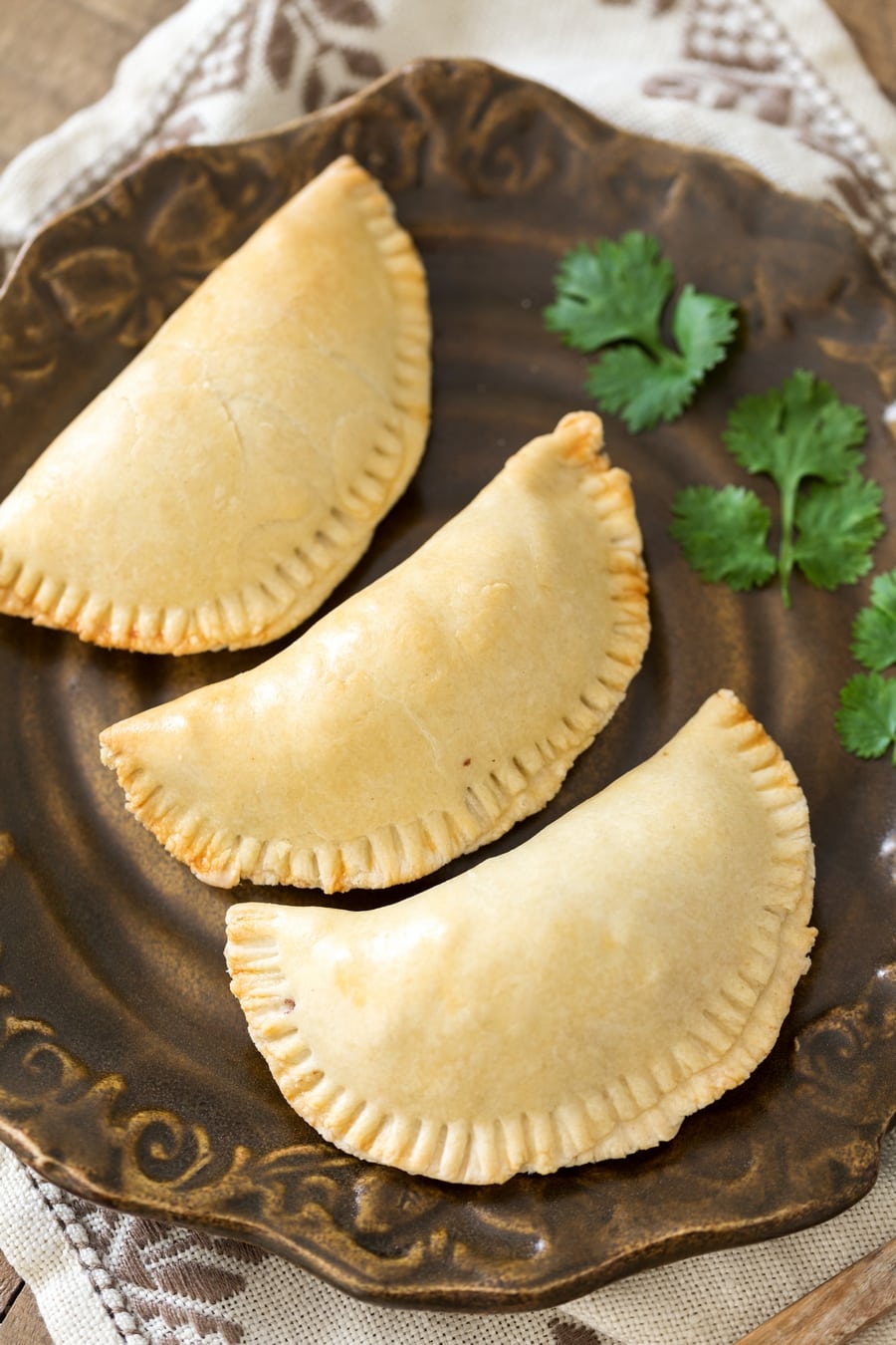 Baked veggie empanadas served on a plate.