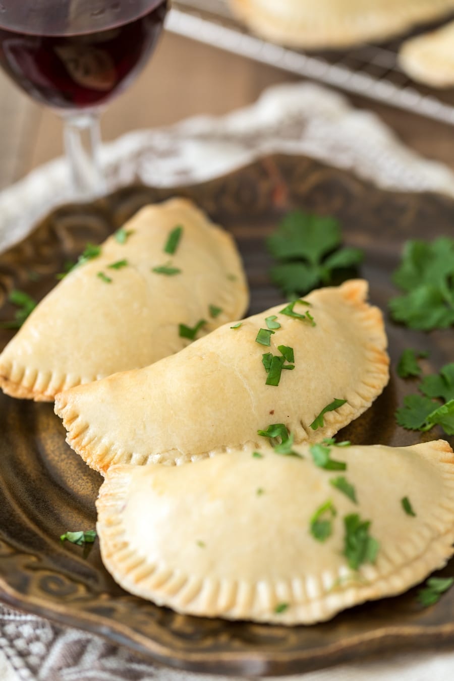 Veggie empanadas plated on a brown plate.