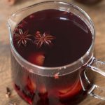 Glass jug with vin brulé. Star anise pods on the surface.