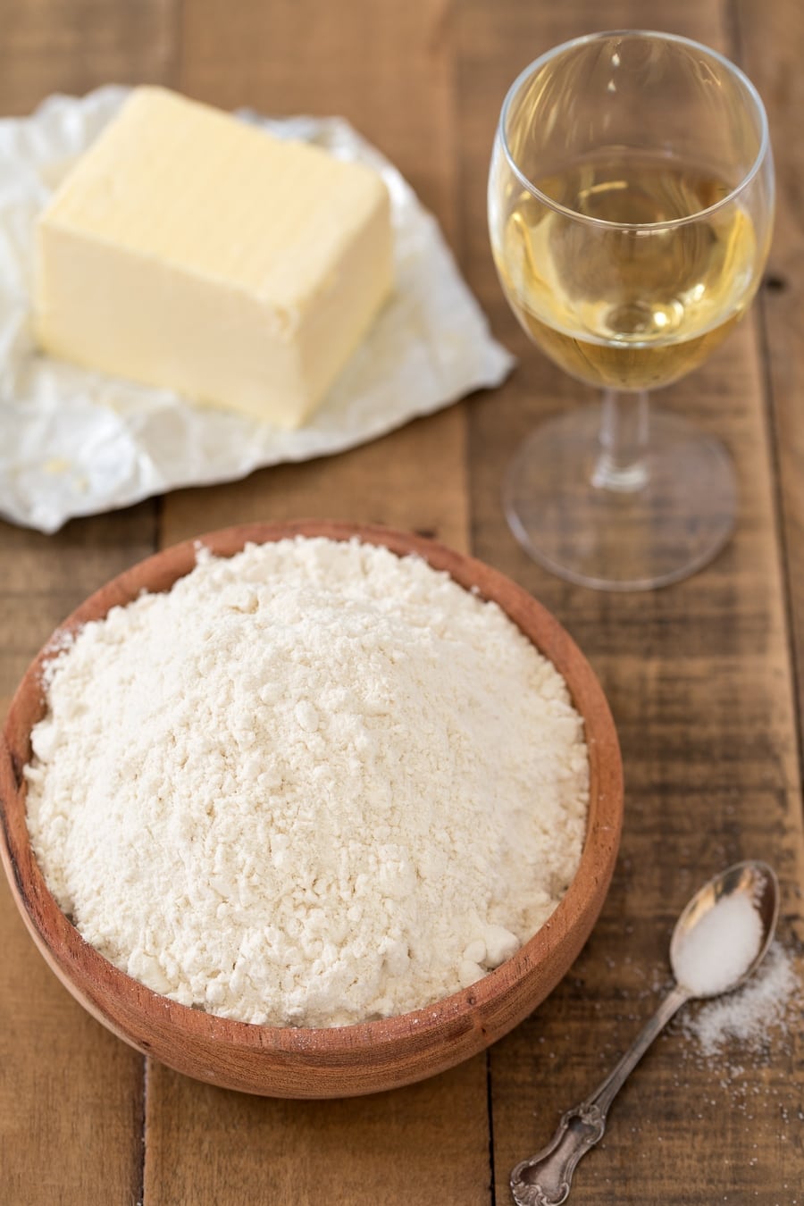 Bowl of flour, white wine glass and butter.