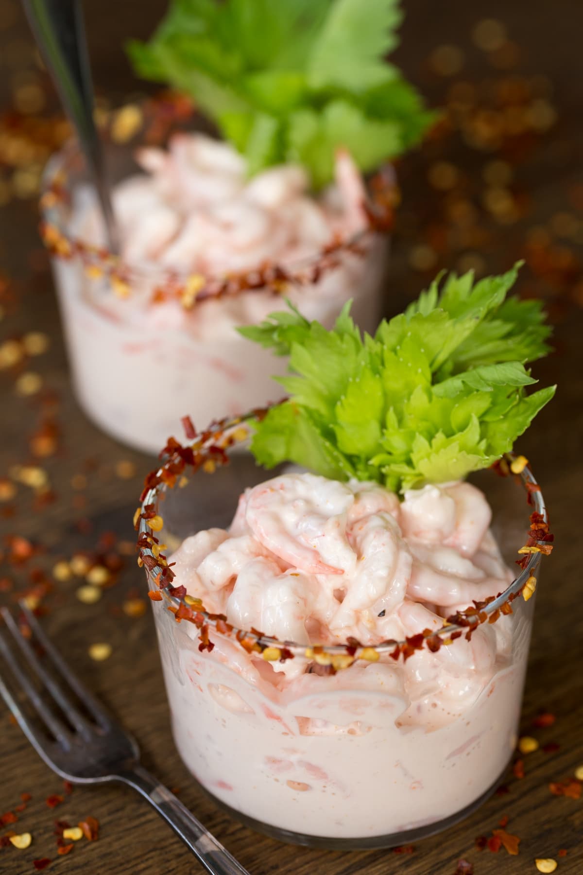 Two portions of shrimp in cocktail sauce.