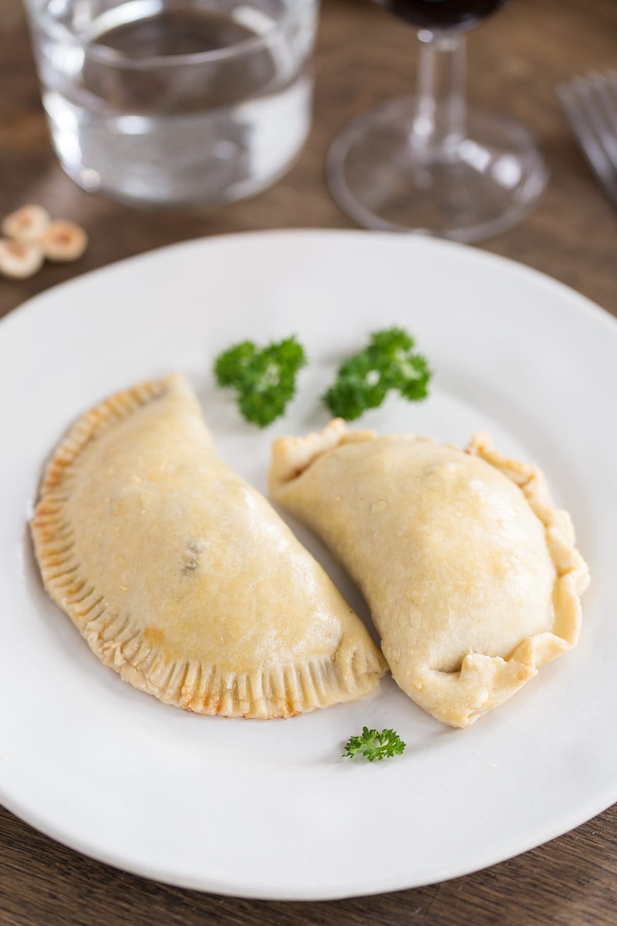 Homemade venison empanadas on white plate.