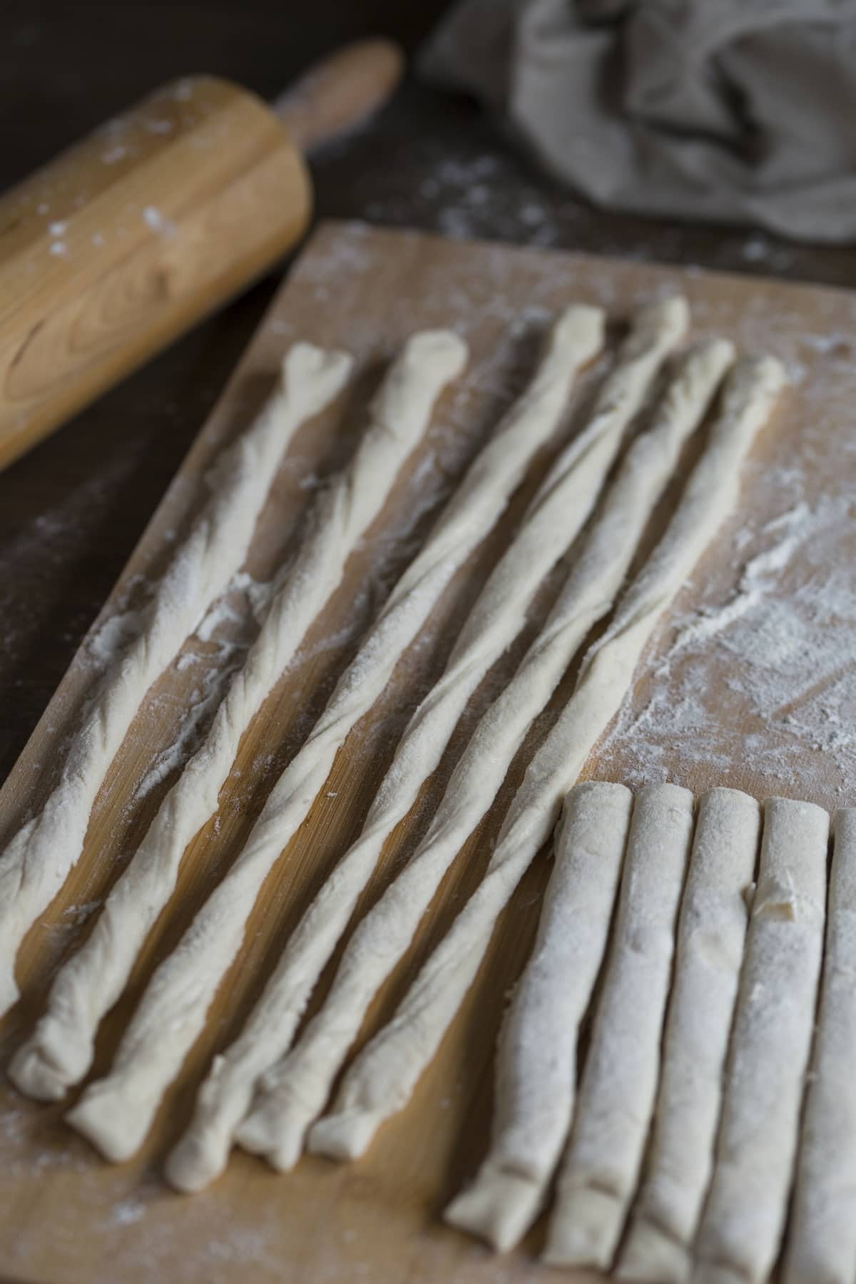 Making sourdough grissini: strips are hand-pulled and lightly twisted.