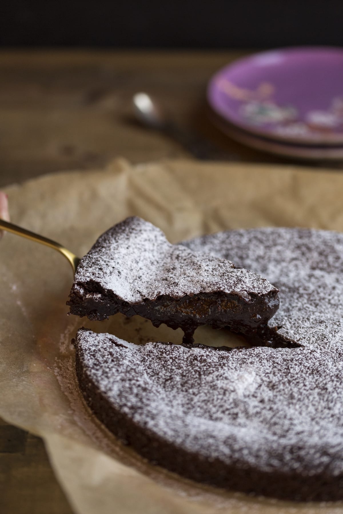 A slice of kladdkaka being lifted on a cake spatula.