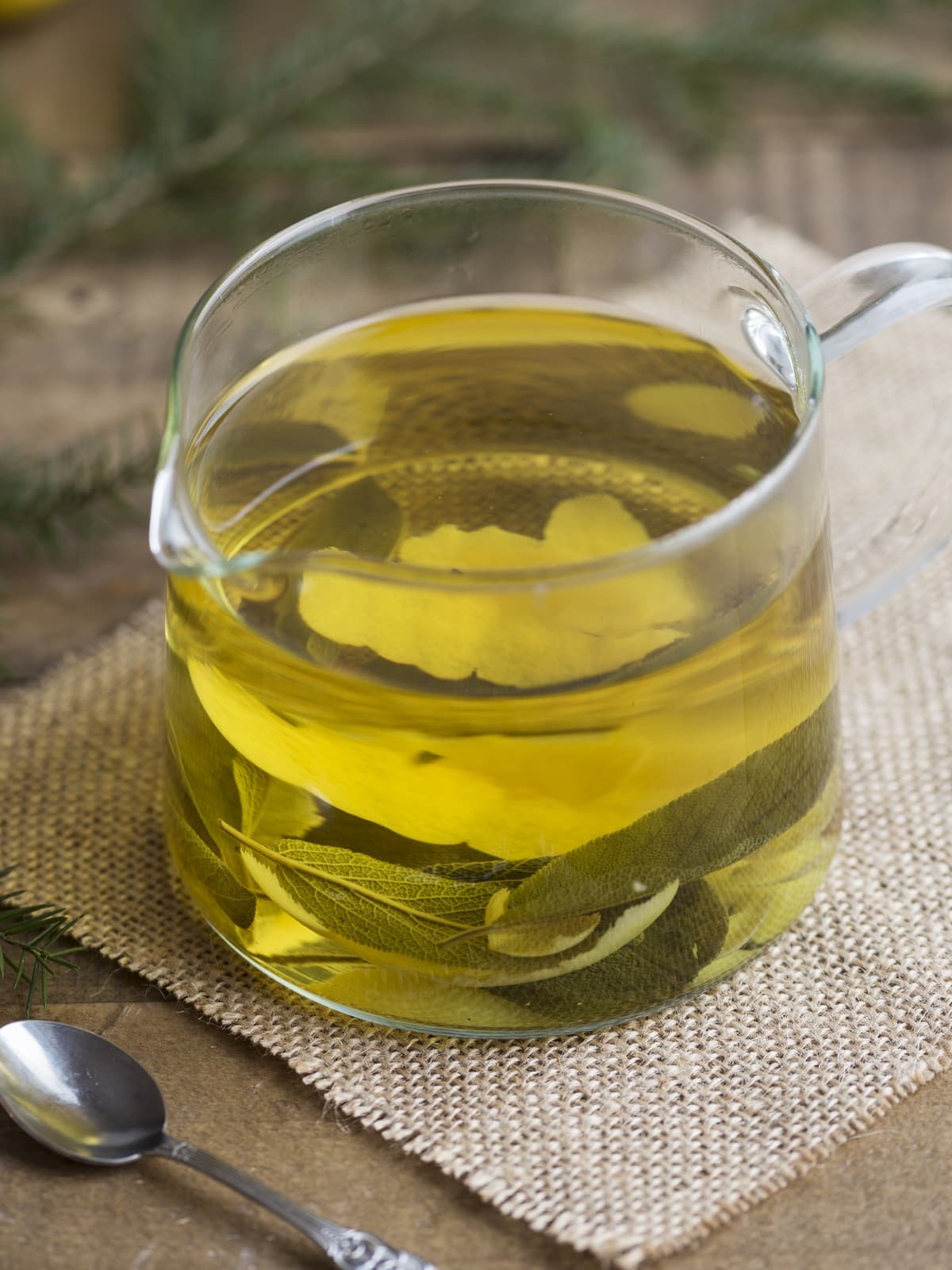 Sage and lemon zest infusion in a see-through jar.