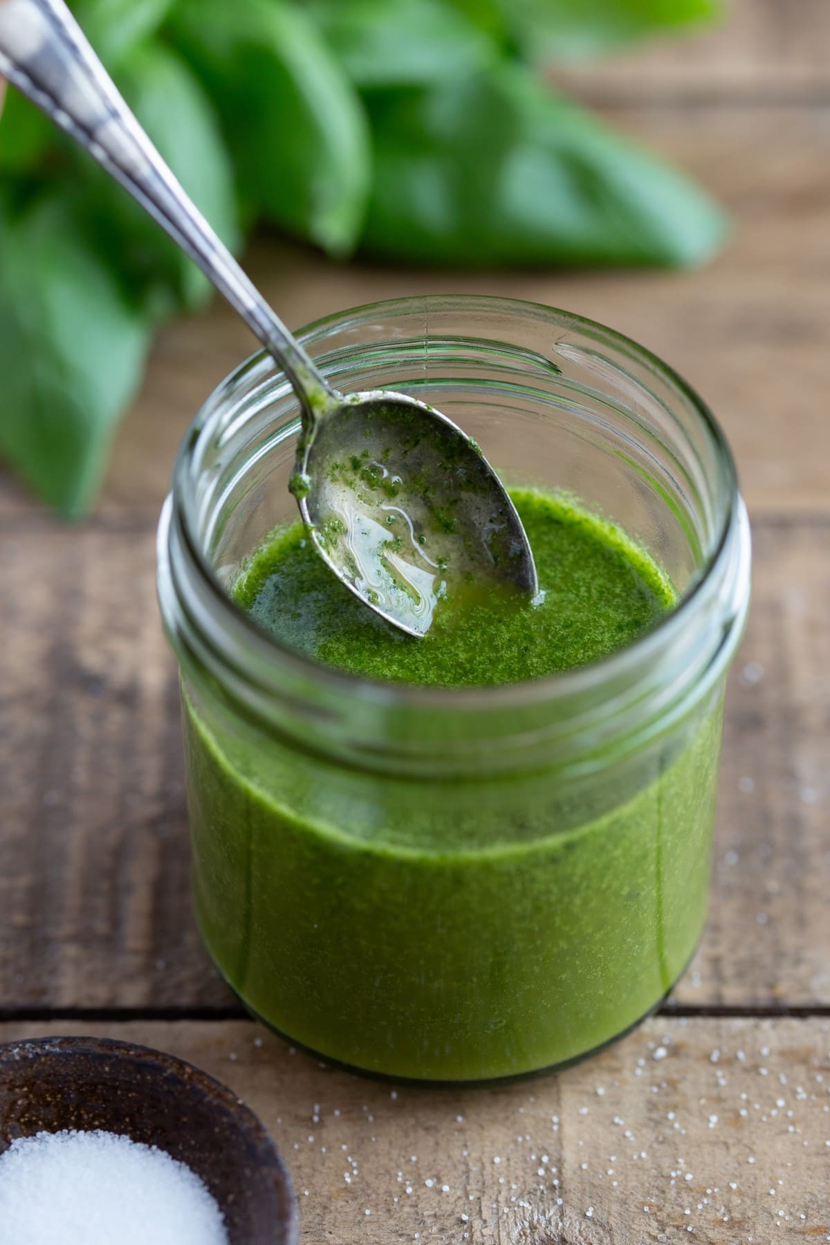 Basil oil dressing in a small jar,