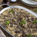 Reindeer stew with mushrooms (renskav) served with a creamy gravy.