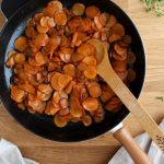 Thinly sliced carrots cooked in a cast iron skillet.
