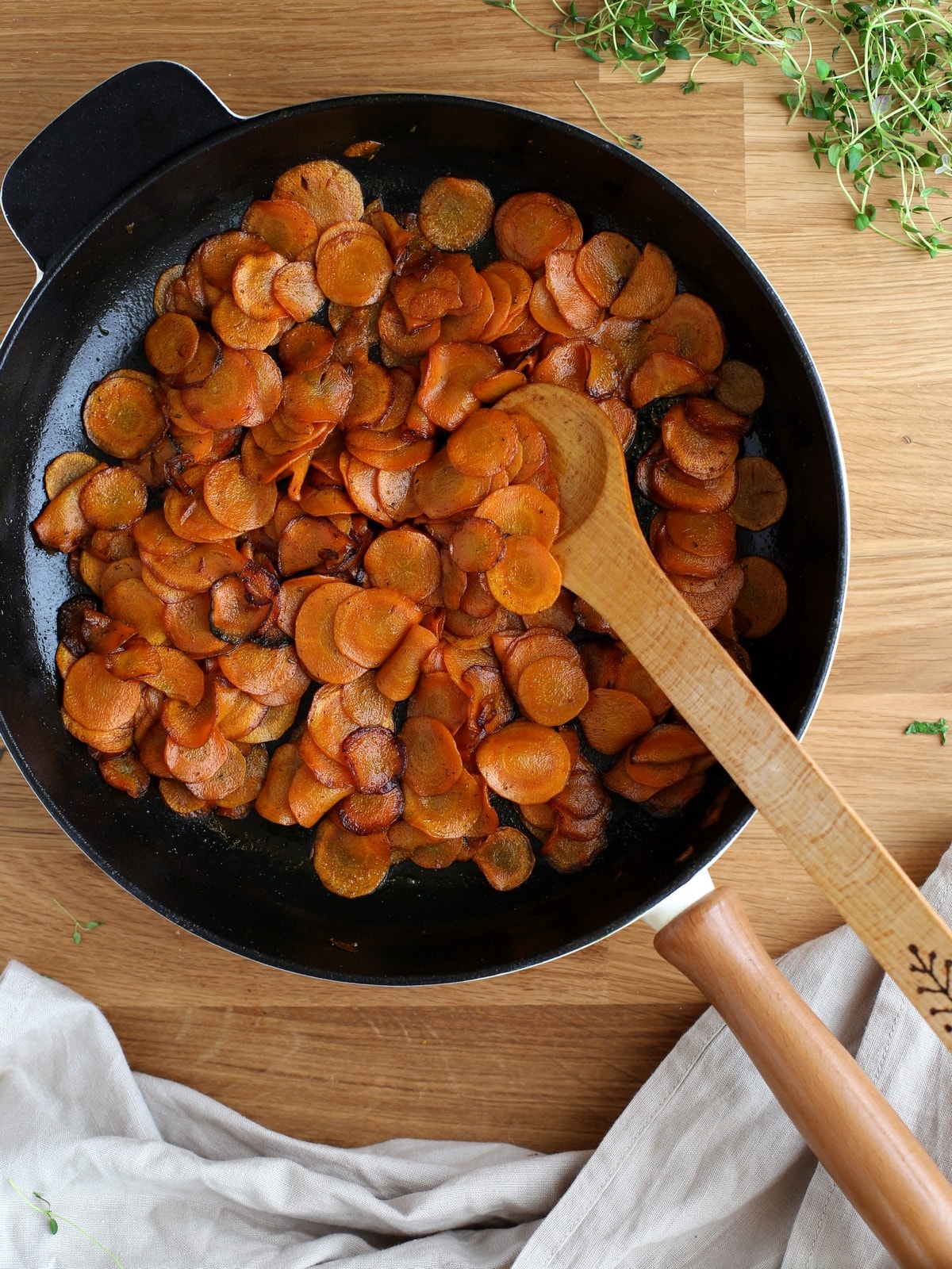 Thinly sliced carrots cooked in a cast iron skillet.
