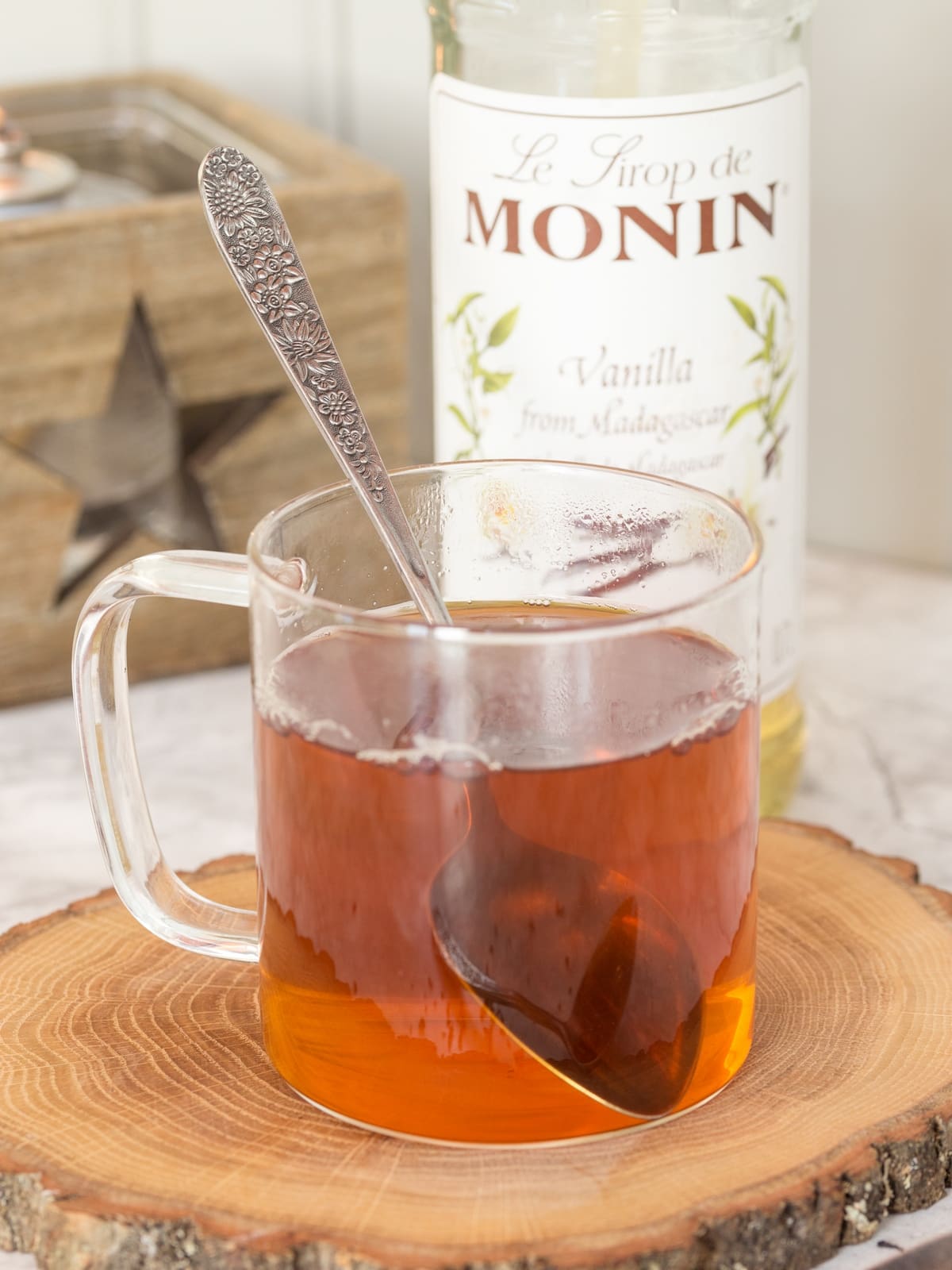 Earl Grey tea in a see-through mug and vanilla syrup in the background.