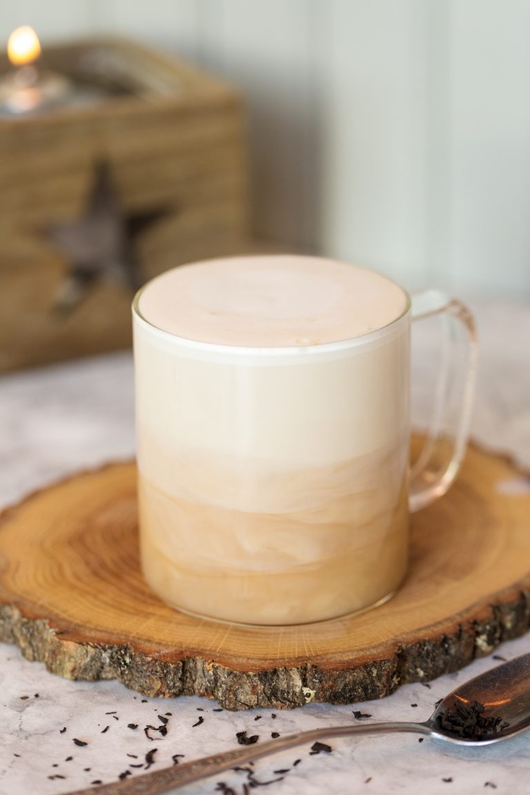 London fog tea latte in a glass mug showing the milk layering over the tea.