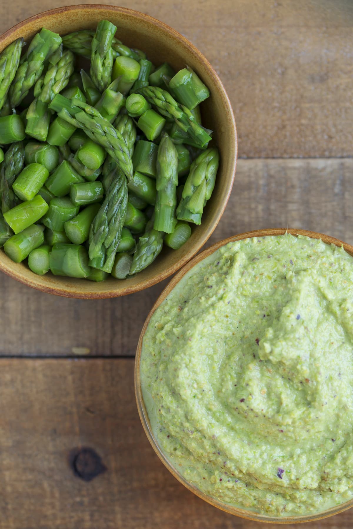 One bowl with puréed asparagus and one with chopped asparagus.