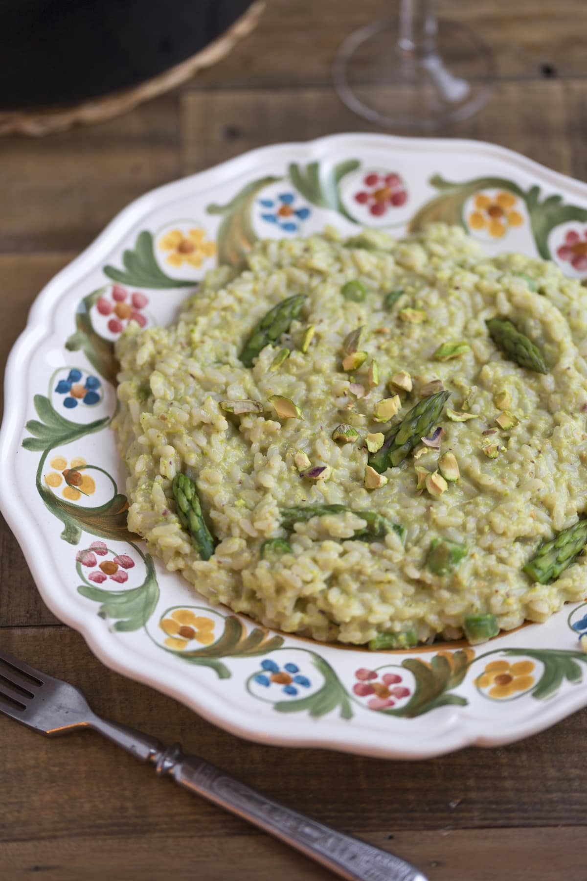 Pistachio asparagus risotto served on a decorated plate.