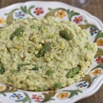 Pistachio asparagus risotto served on a decorated plate.