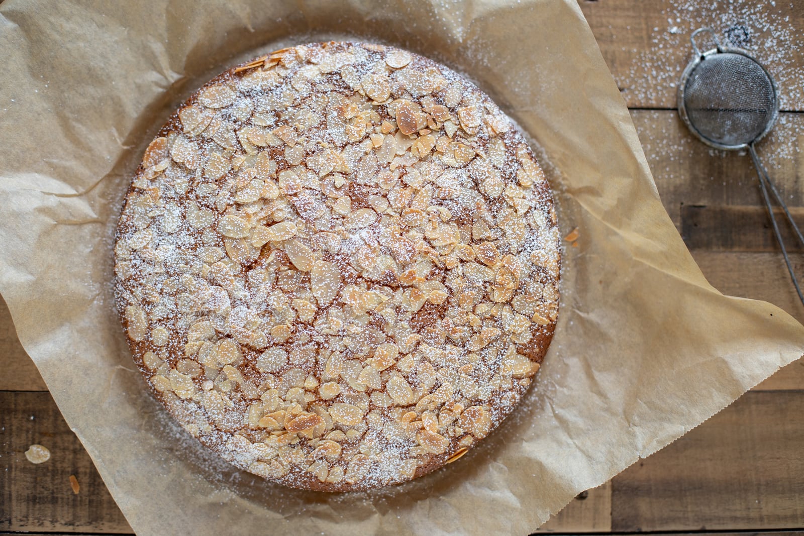 Topping almond carrot cake with powdered sugar.