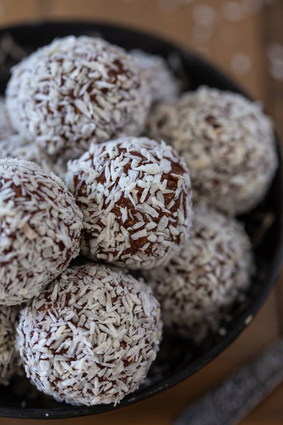 Chocolate oatmeal balls in a black bowl.