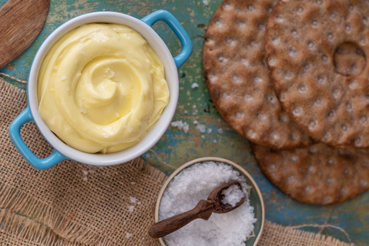 Overhead view of olive oil butter spread next to salt and crispbread.