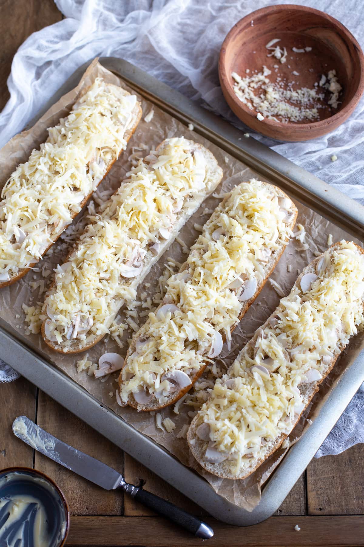 Grated cheese is added on top of the mushrooms.