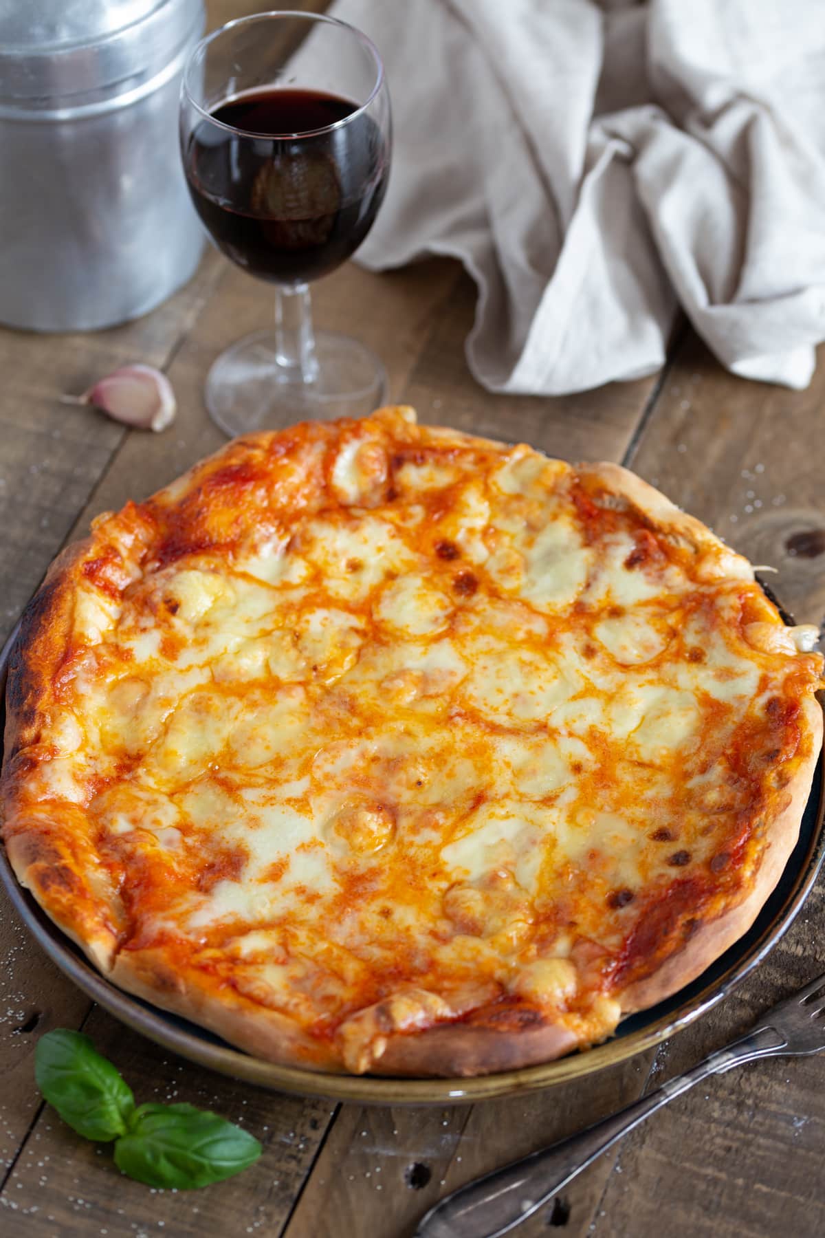 Cheese pizza served with a glass of red wine.