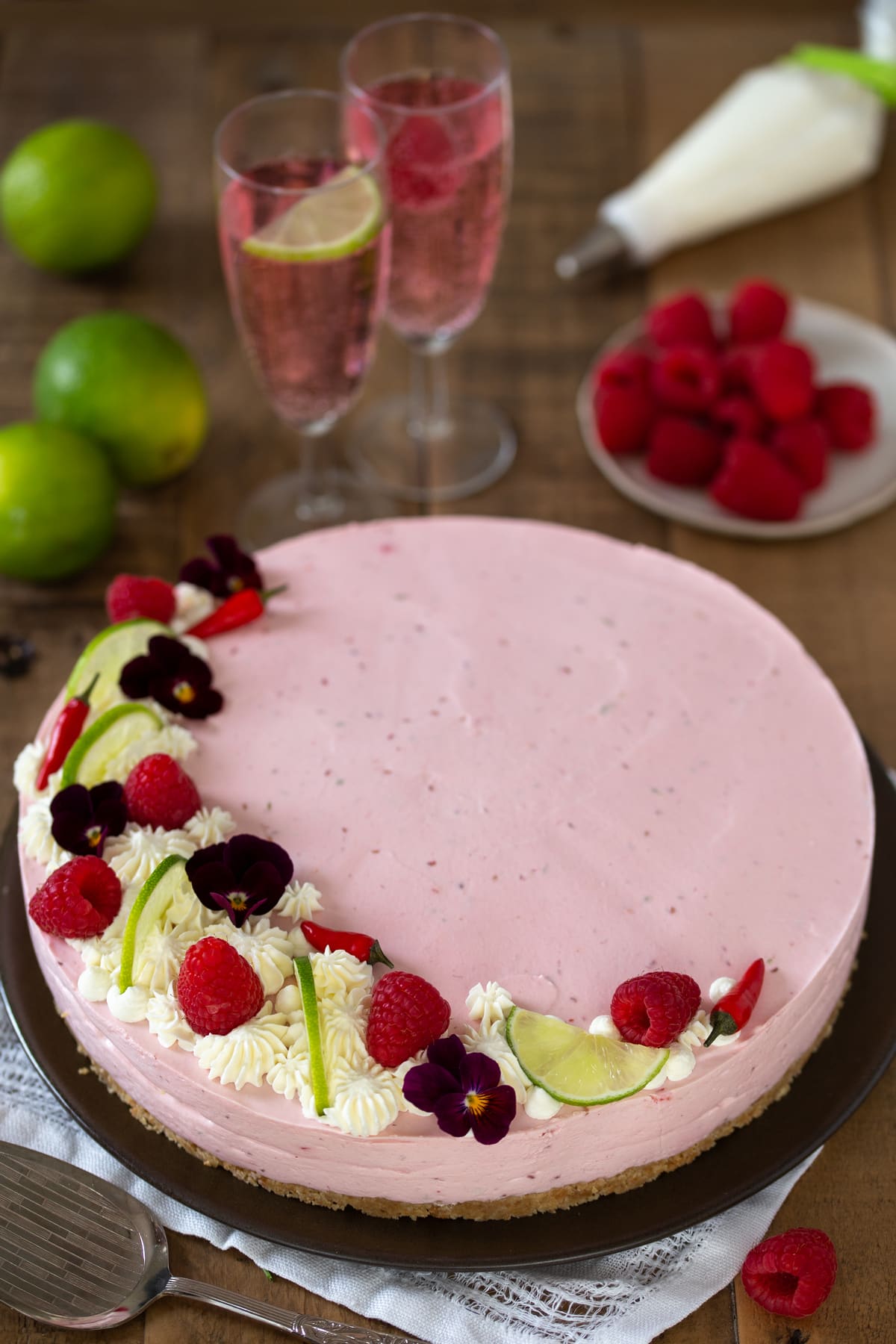 Raspberry chili cheesecake served with raspberry soda in champagne glasses.