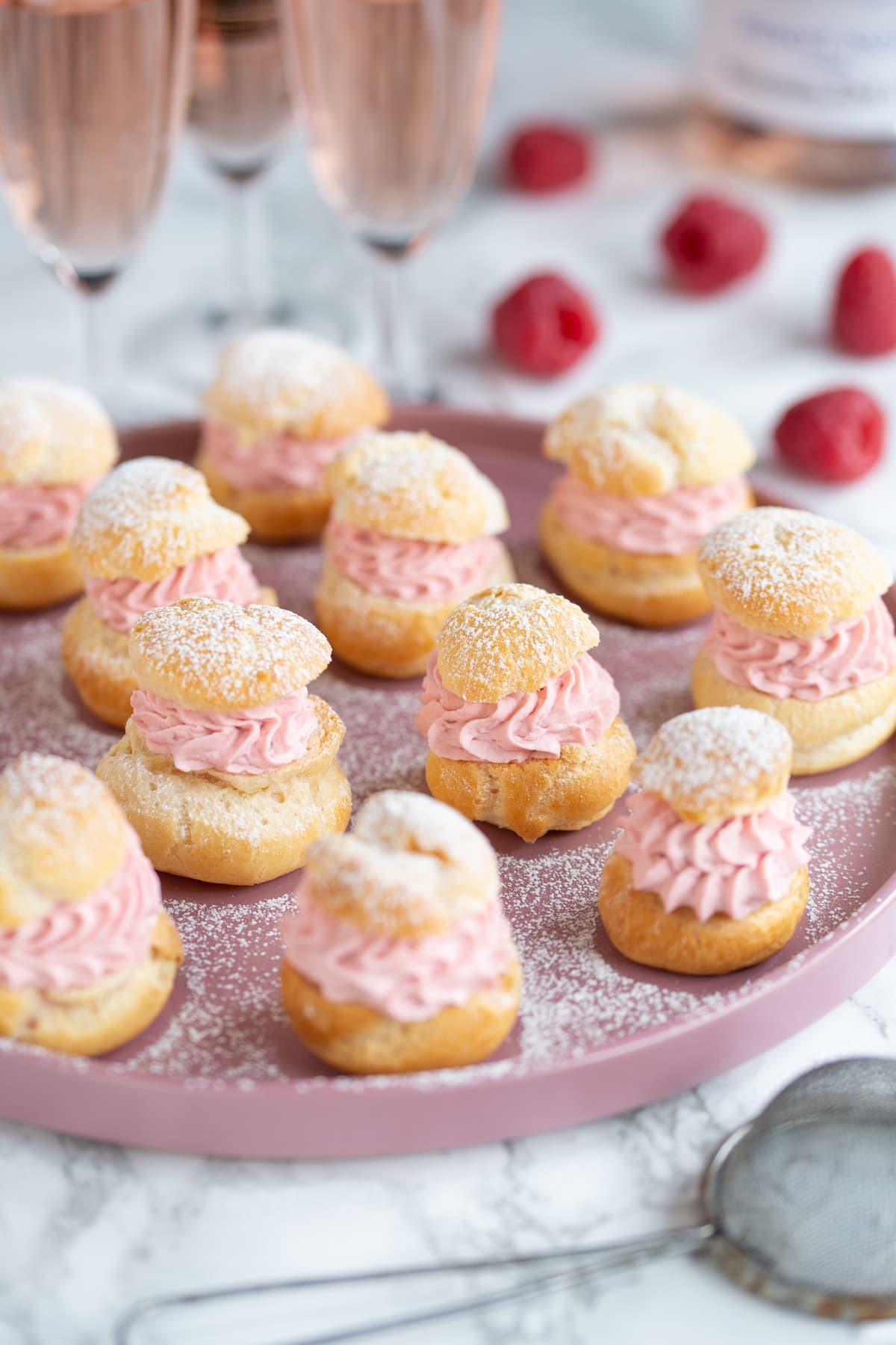 Homemade choux pastry puffs filled with raspberry cream.